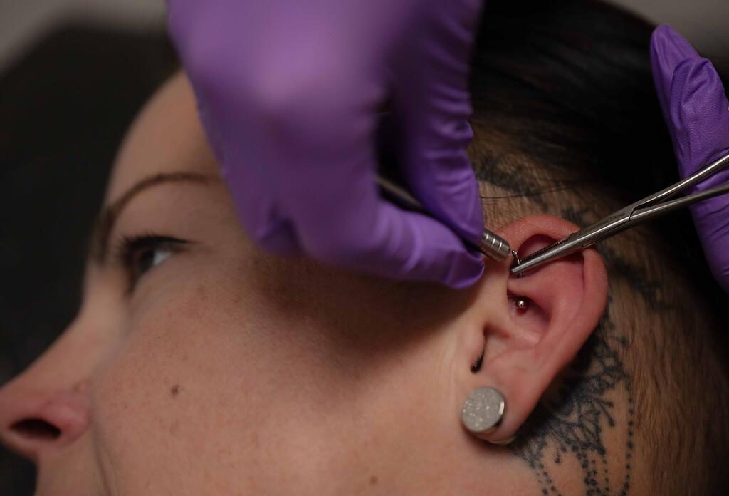 Einsetzen eines Rook Piercings.