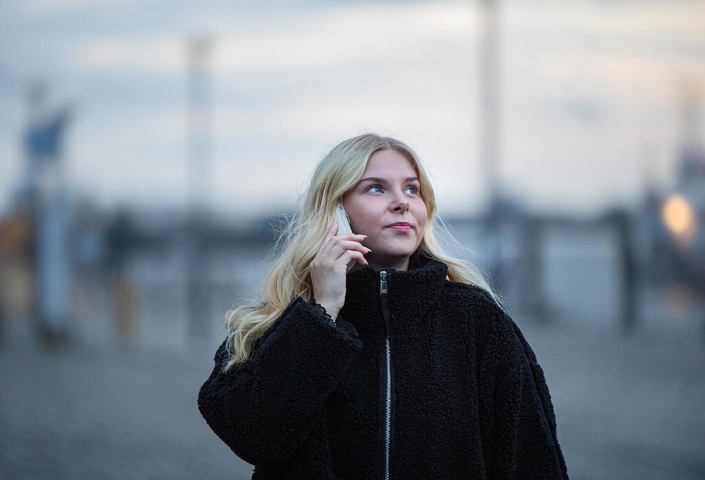 Heimwegtelefon - Handyhotline für ein sicheres Gefühl Frau mit Handy